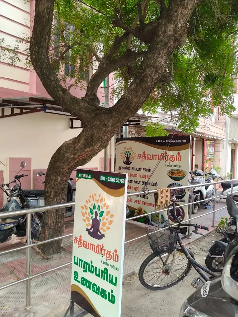 Sathvamirtham restaurant entrance shaded by a tree